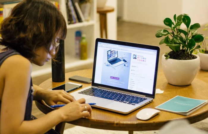 women working at a table with computer in a living room