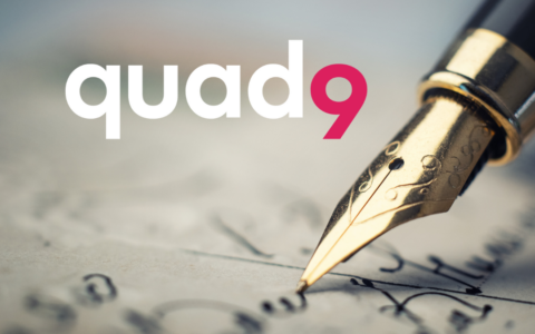background of paper being written on with old antique pen and quad9 logo