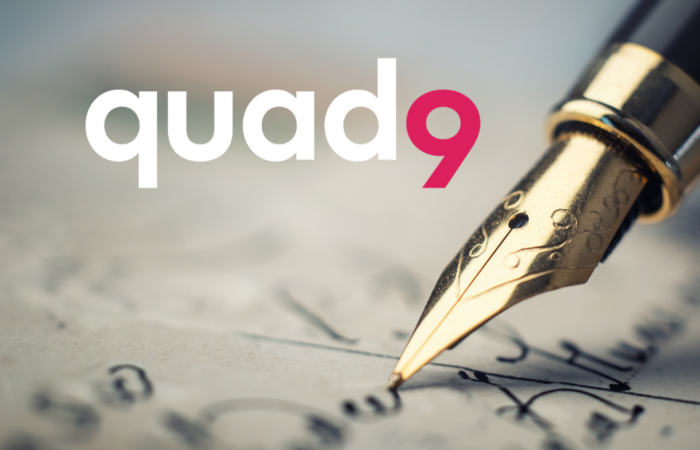 background of paper being written on with old antique pen and quad9 logo