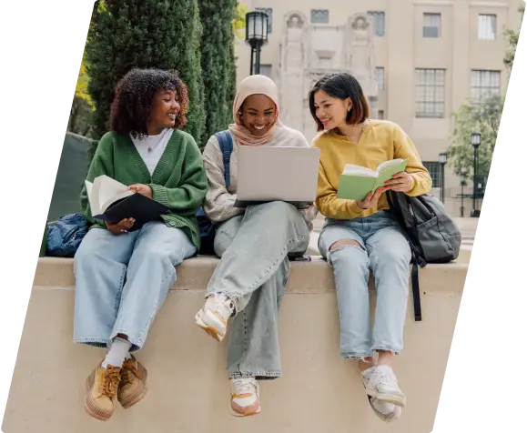 Three female students sitting with their legs hanging down.