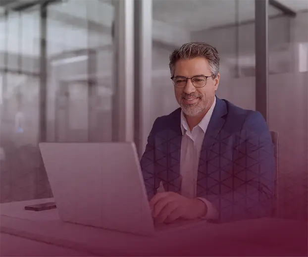 Smiling man in front of his computer.